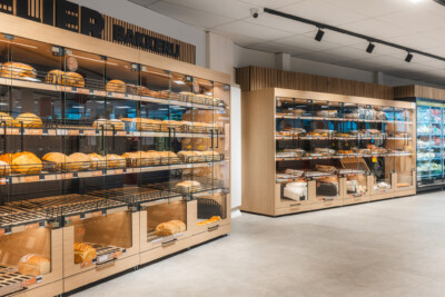 Carrefour Market bakery display with Pitch 25 shelving, tiered black metal racks holding fresh bread and baked goods