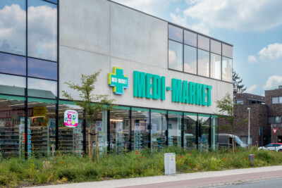 Medi-Market pharmacy storefront with Pitch 25 shelving displaying health and beauty products behind glass windows