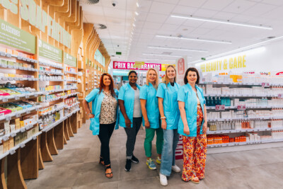 Delhaize supermarket beauty and care section with Pitch 41 shelving and staff in blue uniforms