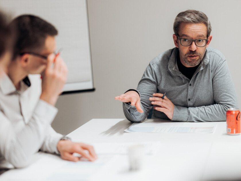 Two professionals in discussion at a meeting table during a Gondella careers event