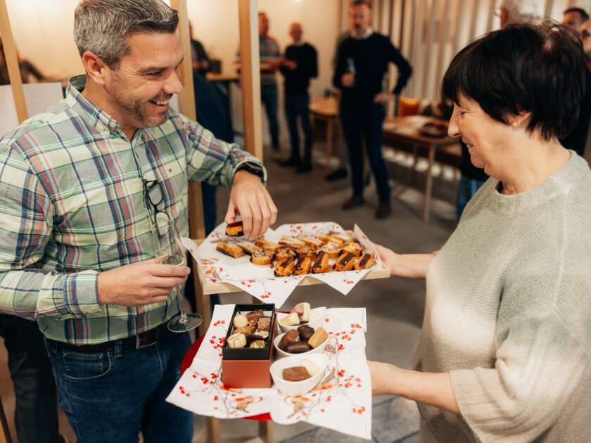Man and woman sampling baked goods at retail event, showcasing food sector hospitality
